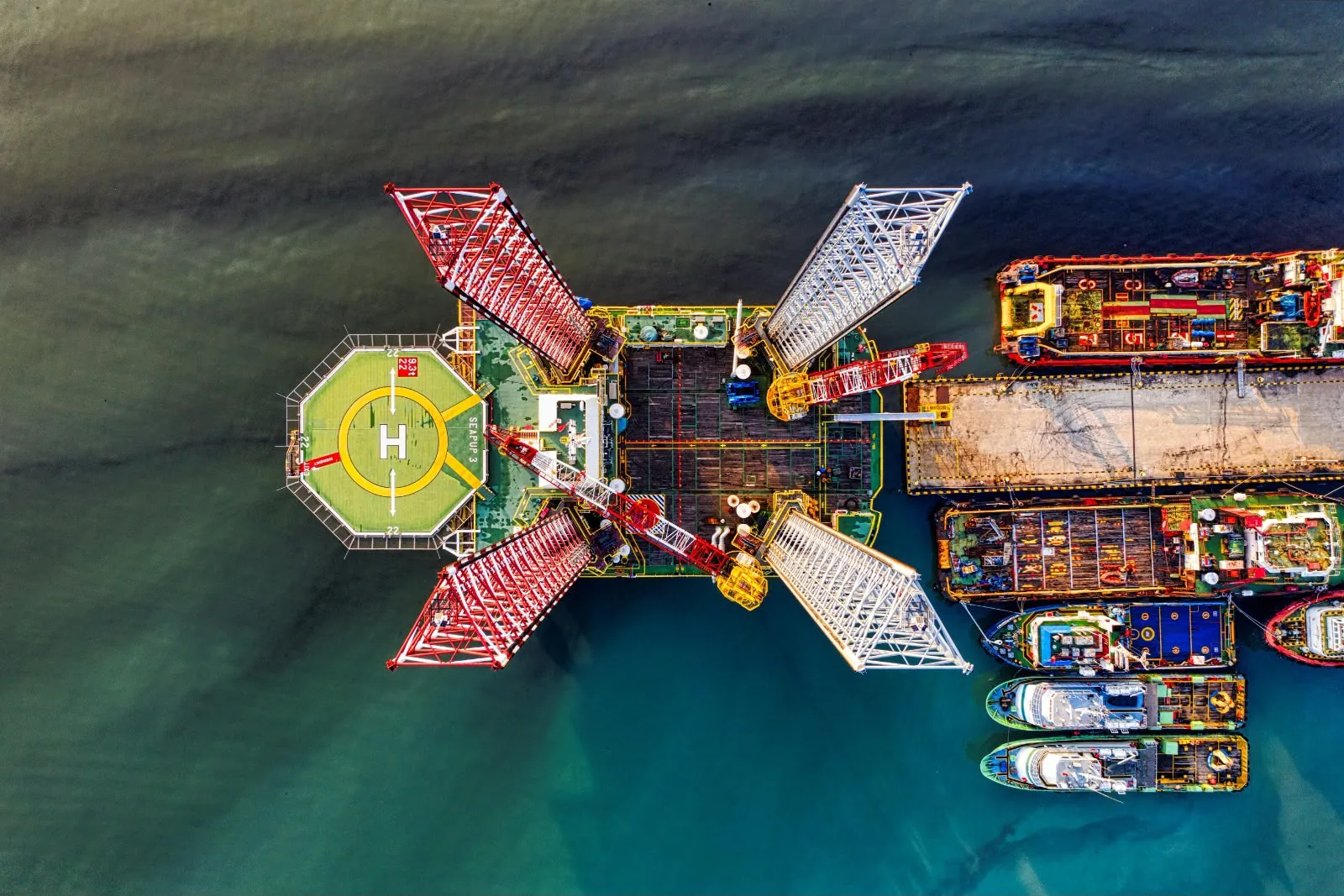 Vista aérea de plataforma offshore e embarcações de apoio